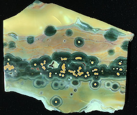 Figure 8: Three different specimens from early mined deposits. The first two show a band of smaller and interspersed spherulites amidst larger spherulites in a chalcedony matrix with reddish color provided by the flow of particulates. A third specimen shows a band of smaller spherulites in a crystalline quartz matrix. Specimen length: ~11cm.